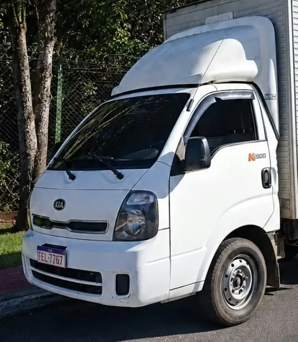 Frente do caminhão baú branco da SOSTAK, usado em fretes e pequenas mudanças
